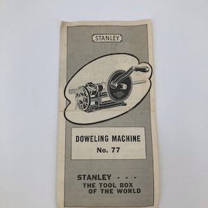 Può includere: Una pubblicità su carta invecchiata per una macchina per tasselli Stanley n. 77. L'illustrazione mostra la macchina in bianco e nero. Il testo recita "Stanley - The Tool Box of the World."