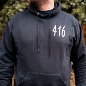 May include: Black hooded sweatshirt with a white "416" printed on the front.