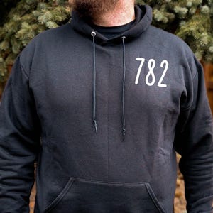 May include: A black hooded sweatshirt with a white number "782" printed on the front.