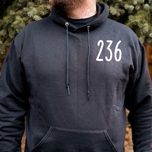 May include: Black hooded sweatshirt with a white number "236" printed on the front.