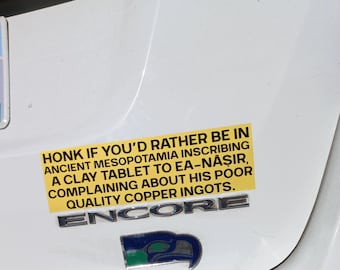 Peut inclure: Un autocollant jaune avec du texte noir qui dit "HONK IF YOU'D RATHER BE IN ANCIENT MESOPOTAMIA INSCRIBING A CLAY TABLET TO EA-NĀṢIR, COMPLAINING ABOUT HIS POOR QUALITY COPPER INGOTS." En dessous, un emblème argenté "ENCORE" et un emblème bleu et vert.