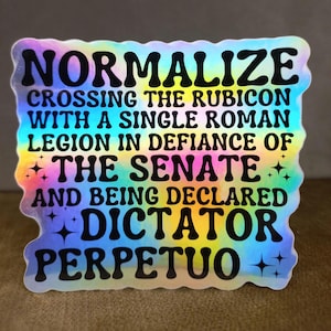 Puede incluir: Una pegatina holográfica con fondo arcoíris y texto negro que dice "Normalizar cruzar el Rubicon con una sola legión romana en desafío al Senado y ser declarado dictador perpetuo".