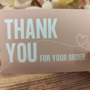 May include: A pink thank you card with white text that says "Thank You for your order" and a white heart.