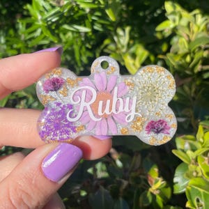 Front side of purple floral dog tag, floral dog tag, purple and white dog tag, dog bone tag