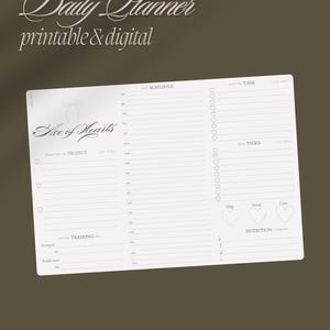 Peut inclure: Un agenda quotidien blanc avec le texte "Daily Planner printable & digital" en haut. L'agenda est divisé en deux sections : "Schedule" et "Task". La section "Schedule" contient une liste d'heures de 6h00 à 23h00. La section "Task" contient une liste de tâches avec des cases à cocher. L'agenda comprend également une section pour "Project", "Training" et "Nutrition".