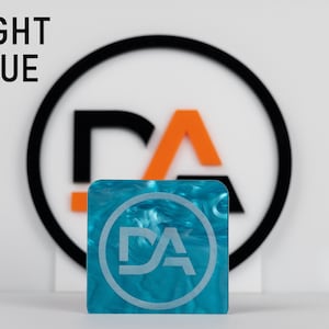 May include: A light blue square acrylic sheet with a white swirl pattern. The sheet has a circular logo with the letters "DA" in white.