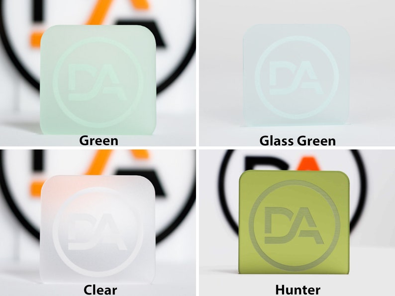 May include: Four square glass blocks in green, glass green, clear, and hunter green. Each block features a circular logo with the letters "DA". The colours are labelled below each block.
