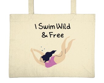 May include: A beige tote bag with a black and white illustration of a person swimming underwater. The text "I Swim Wild & Free" is printed on the bag.