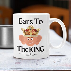 Unique ceramic coffee mug, 11oz, with a cute cartoon king Charles character with large ears and a golden crown, with the text ' Ears to the King' ideal for fans of the royal family, monarchy and humorous gifts
