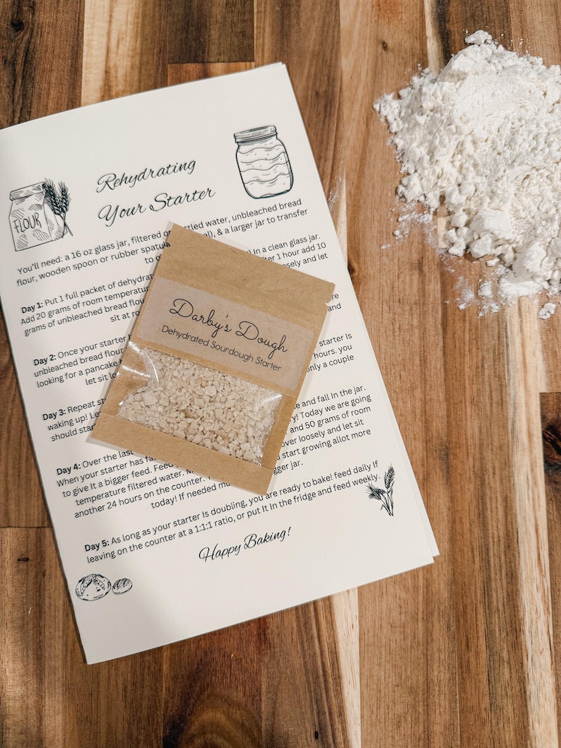 Puede incluir: Instrucciones para rehidratar un fermento de masa madre con un paquete de fermento de masa madre deshidratado. Las instrucciones incluyen los pasos para alimentar el fermento y una nota sobre la felicidad de hornear.