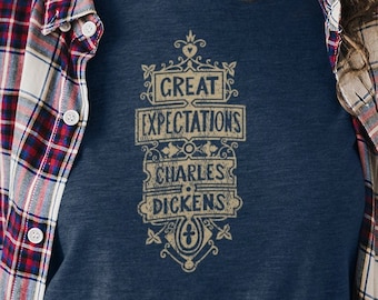 May include: A navy blue t-shirt with a gold graphic design featuring the text "Great Expectations Charles Dickens".