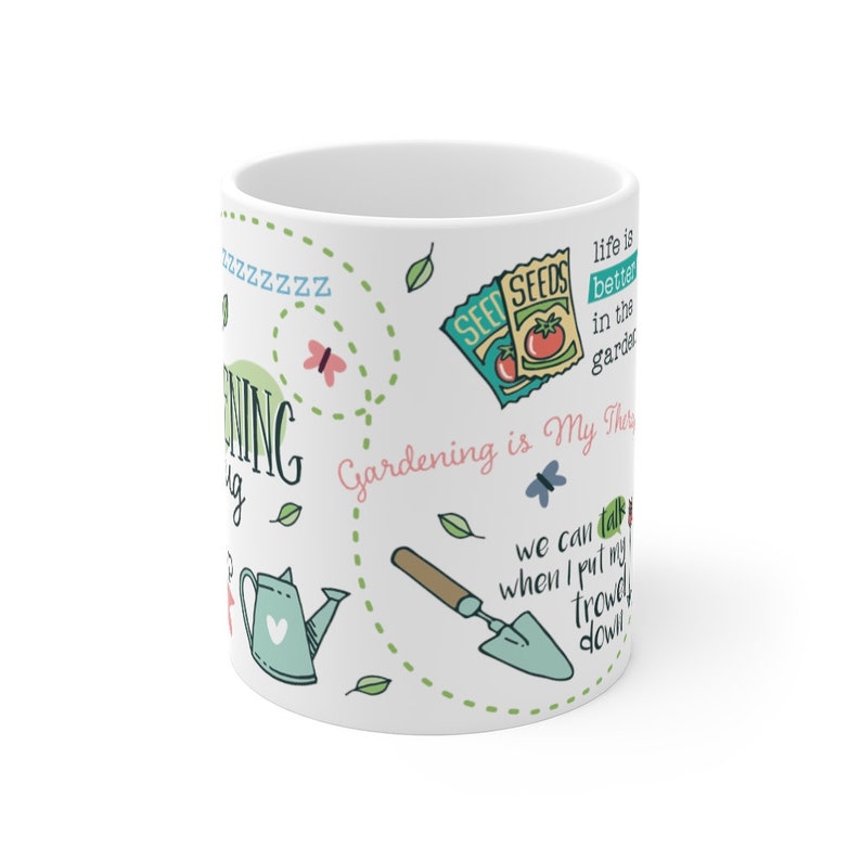 Puede incluir: Taza de cer&aacute;mica blanca con un dise&ntilde;o verde, rosa y azul con ilustraciones y texto sobre el tema de la jardiner&iacute;a. El texto dice "La jardiner&iacute;a es mi terapia" y "La vida es mejor en el jard&iacute;n".