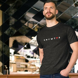 May include: A dark gray t-shirt with a white graphic that says "SMTWTFS" with a red heart in place of the "O".