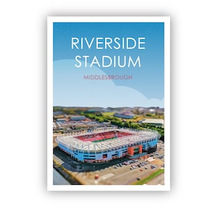 Könnte beinhalten: Eine Luftaufnahme des Riverside Stadium in Middlesbrough, England. Das Stadion ist ein großes, modernes Fußballstadion in blau-roter Farbgebung. Das Stadion ist von einem Parkplatz und einem Rasenfeld umgeben.