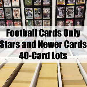 May include: A close-up of a collection of football trading cards organized in rows. The sign above reads "Football Cards Only Stars and Newer Cards 40-Card Lots".