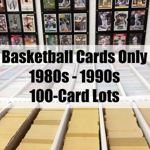 May include: A collection of basketball trading cards from the 1980s and 1990s, organized in rows of 100-card lots. The cards are stored in clear plastic sleeves and are displayed in a white storage unit.