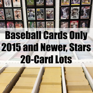 May include: A close-up of a shelf filled with baseball cards. The cards are organized in rows and are all in protective sleeves. The sign above the shelf reads "Baseball Cards Only 2015 and Newer, Stars 20-Card Lots".