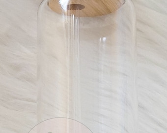 Könnte beinhalten: Ein durchsichtiger Glasbecher mit einem Bambusdeckel und einem durchsichtigen Strohhalm. Der Becher hat eine zylindrische Form und ist für kalte Getränke konzipiert. Der Deckel hat ein Loch für den Strohhalm. Das Logo "BLANKITY BLANKS" ist sichtbar.