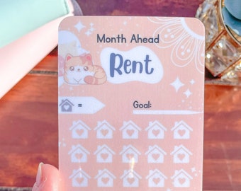 May include: A pink and white printable tracker with a cute cartoon cat and the text "Month Ahead Rent" and "Goal:". The tracker has a grid of 36 small houses with hearts inside. The bottom of the tracker says "Home Sweet Home Little Potato Saver".