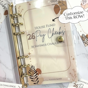 May include: A clear plastic binder with gold rings holds a light brown and beige planner with the text "House Fund 26 Pay Checks 1K Savings Challenge" and "Little Potato Saver". The planner has a floral design with brown and beige accents. The text "Customize This ROW!" is written in a speech bubble with an arrow pointing to the planner.
