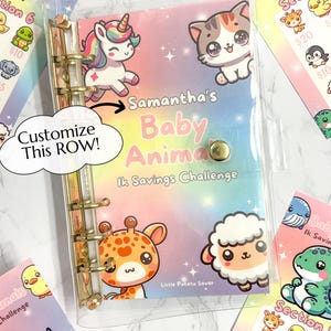 May include: A clear plastic binder with a colourful design featuring baby animals. The binder has gold rings and a title that reads "Samantha's Baby Animal 1k Savings Challenge".