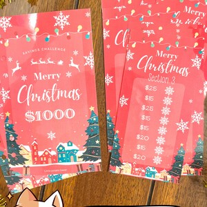 Pode incluir: Um rastreador de desafios de poupan&ccedil;a de Natal imprim&iacute;vel vermelho e branco com uma ilustra&ccedil;&atilde;o de vila de inverno festiva e o texto "Feliz Natal 1000 &euro;".