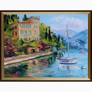 May include: Oil painting depicting a coastal scene with a sailboat and a large building. The artwork features a white sailboat with a red accent, a yellow building, and mountains in the background. The water reflects the sky and surrounding landscape.