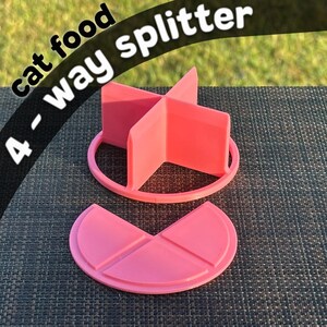 May include: Pink plastic cat food splitter with four sections. The splitter is designed to divide food into four equal portions. The text "cat food 4-way splitter" is visible in the image.