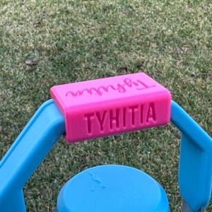 May include: A pink plastic handle with the words "Tyhtia" and "Mylly" printed on it. The handle is attached to a blue plastic object.