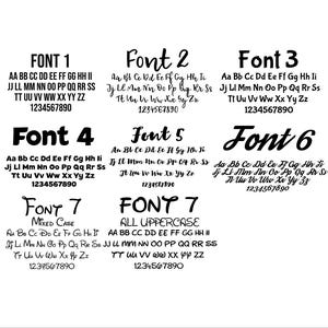 Op de afbeelding: Op een witte achtergrond worden zeven verschillende lettertypen weergegeven, elk gemarkeerd met "FONT" en een nummer. Elk lettertype toont het alfabet in hoofdletters en kleine letters, samen met cijfers. De lettertypen vari&euml;ren in stijl, van vetgedrukt tot cursief.