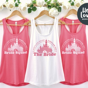 May include: Three pink and white tank tops with a graphic of Cinderella's castle and the text "Madi's Last Splash Disneyland 2022" on each. One tank top says "The Bride" and the other two say "Bride Squad".