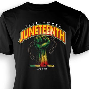 Könnte beinhalten: Schwarzes T-Shirt mit einer Grafik einer geballten Faust in den Farben der panafrikanischen Flagge, mit Ketten und den Worten "Juneteenth" und "Freedom Day". Das Shirt enthält auch den Text "From Their Roots, I Thrive. June 19, 1865."