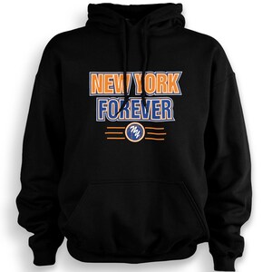 Könnte beinhalten: Ein schwarzer Kapuzenpullover mit dem Text NEW YORK FOREVER in orangefarbenen und blauen Blockbuchstaben auf der Brust. Unter dem Text befindet sich ein kreisförmiges Emblem mit einem weißen Kringel-Design, flankiert von drei horizontalen Linien.