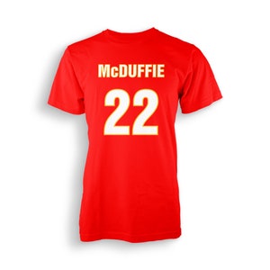 Può includere: Maglietta rossa con il nome "McDuffie" e il numero "22" stampati in bianco con un contorno giallo.