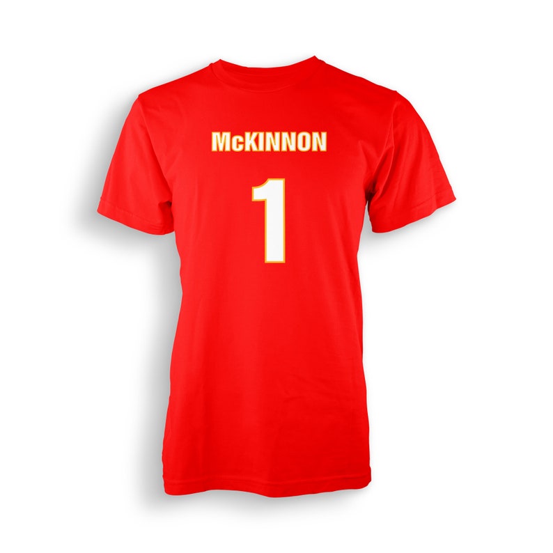 以下が含まれることがあります： 黄色の輪郭で白く「MCKINNON」と「1」と書かれた赤いTシャツ