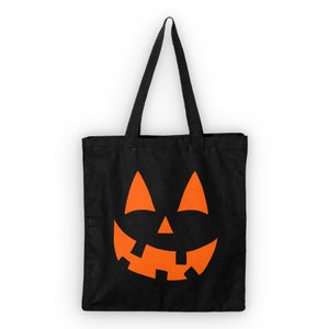 May include: Black canvas tote bag with an orange jack-o'-lantern face design.