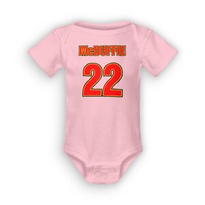 Può includere: Body rosa per neonato con il nome "McDuffie" e il numero "22" stampato in rosso con un contorno giallo.