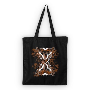 Könnte beinhalten: Schwarze Stofftasche mit einem weißen Grafikdruck von zwei stilisierten Tiergesichtern mit braunen Spritzfarben-Akzenten.
