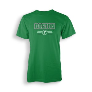 Könnte beinhalten: Ein grünes T-Shirt mit einer weißen Grafik, auf der "BOSTON" steht, darunter ein weißer Kreis mit einem weißen "B".