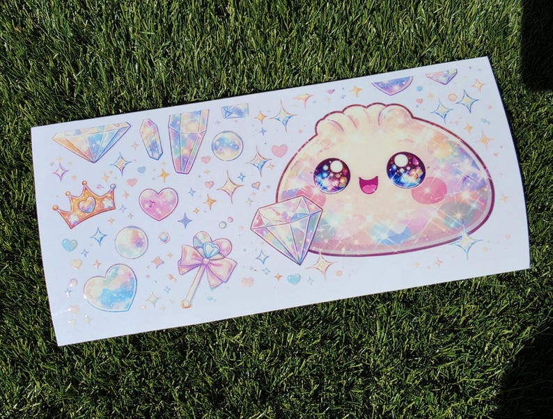May include: A rectangular sticker sheet featuring a large, smiling, iridescent dumpling character with galaxy-filled eyes, surrounded by various pastel-colored illustrations including diamonds, crystals, a crown, hearts, and a magical wand.