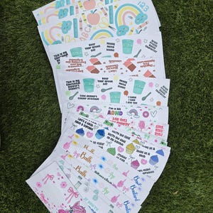 May include: A collection of rectangular sticker sheets featuring various colorful designs, including rainbows, apples, ice cream cups, cupcakes, and a pink unicorn. The sheets contain printed text phrases like 'Brain Freeze builds character' and 'I'm a bit ADHD'.