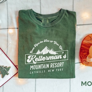 Puede incluir: Una camiseta verde con un diseño gráfico blanco que dice "Come Have the Time of Your Life Kellerman's Mountain Resort Catskills. New York".