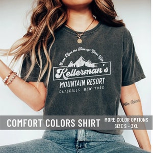Op de afbeelding: Een donkergrijs T-shirt met een wit grafisch ontwerp met de tekst "Come Have the Time of Your Life Kellerman's Mountain Resort Catskills New York". Het shirt is een Comfort Colors shirt en is verkrijgbaar in de maten S-3XL.