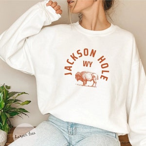 May include: White sweatshirt with a brown graphic of a bison and the text "JACKSON HOLE WY" in an arch.