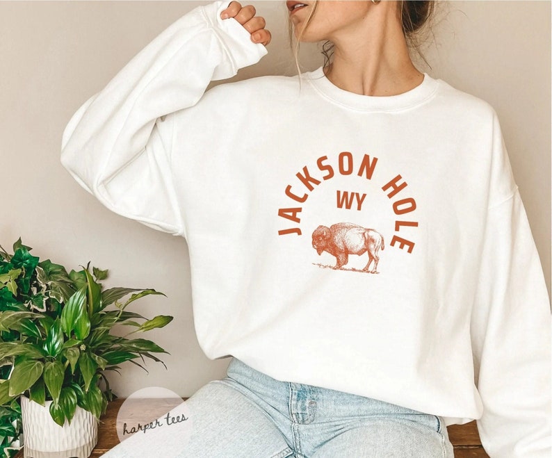 May include: White sweatshirt with a brown graphic of a bison and the text "JACKSON HOLE WY" in an arch.