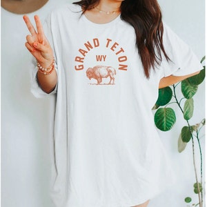 May include: White oversized t-shirt with a brown graphic of a buffalo and the text "GRAND TETON WY" in a circle.