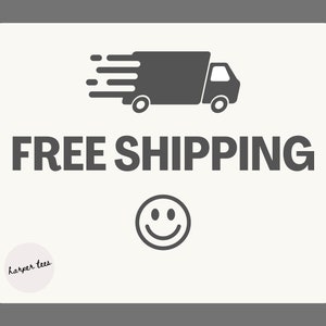 May include: A white sign with a gray truck icon and the text "FREE SHIPPING" in black. A gray smiley face is below the text. The text "harper tees" is in a circle at the bottom left corner of the sign.