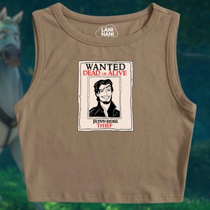 K&ouml;nnte beinhalten: Ein braunes, &auml;rmelloses Crop-Top mit einem schwarz-wei&szlig;en Aufdruck eines Fahndungsplakats. Das Plakat zeigt Flynn Rider, eine Figur aus dem Disney-Film Rapunzel - Neu verf&ouml;hnt, und tr&auml;gt die Aufschrift "WANTED DEAD OR ALIVE" und "FLYNN RIDER THIEF".