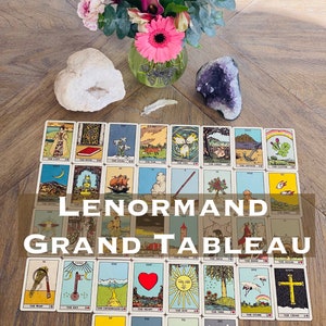 May include: A Lenormand Grand Tableau tarot card spread with various illustrated cards. The cards are arranged on a wooden surface, with a vase of flowers, crystals, and a feather nearby. The text "LENORMAND GRAND TABLEAU" is overlaid on the cards.