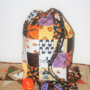 May include: A Halloween-themed drawstring bag made of patchwork fabric with various designs, including pumpkins, bats, cats, candy corn, and spiders. The bag is purple, orange, black, and white.